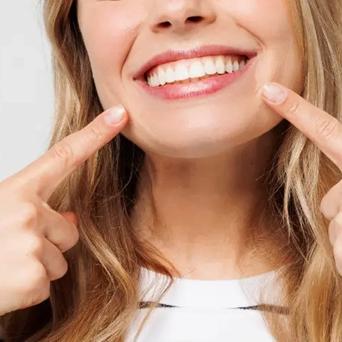woman pointing at her smile