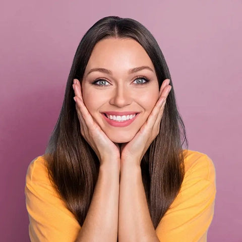 woman smiling hands on face